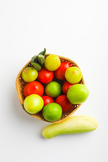 Vegetais crus em uma tigela de madeira no fundo branco