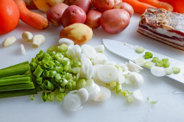 Vegetais da primavera e bacon na mesa da cozinha Alimentos saudáveis estão na mesa Comida caseira