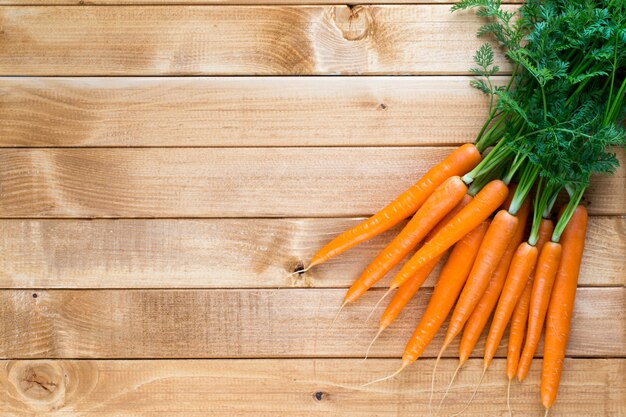 Vegetais de cenoura com folhas no fundo de madeira