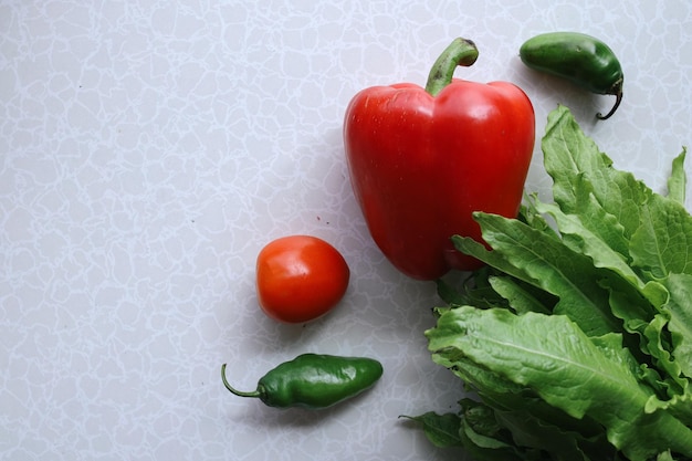 Vegetais de folhas verdes com pimentão verde, pimenta vermelha, vegetais de folhas e tomate