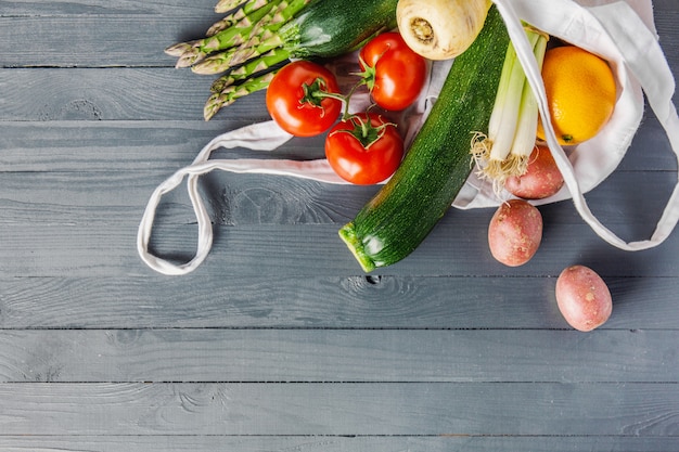 Vegetais diferentes em saco têxtil em cinza