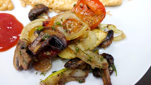 Vegetais e cogumelos grelhados servidos num prato branco com ketchup
