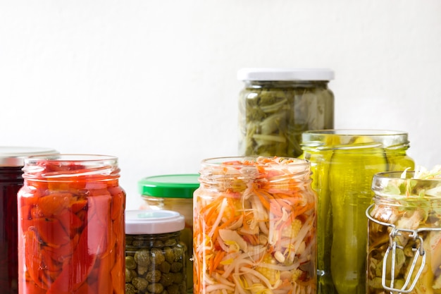 Foto vegetais preservados fermentados em pote na mesa de madeira.