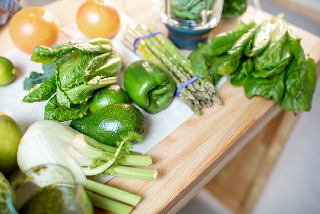 Vegetais verdes crus na mesa da cozinha