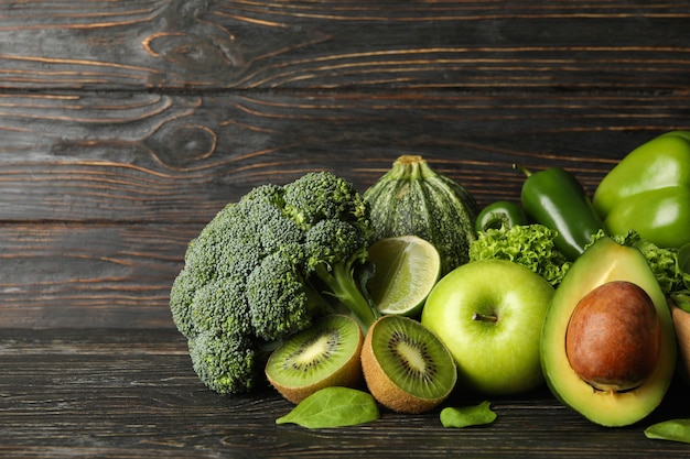 Vegetais verdes e frutas em fundo de madeira