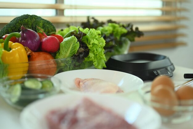 Vegetales frescos y carne cruda en la mesa de la cocina Alimentos saludables concepto nutritivo y culinario