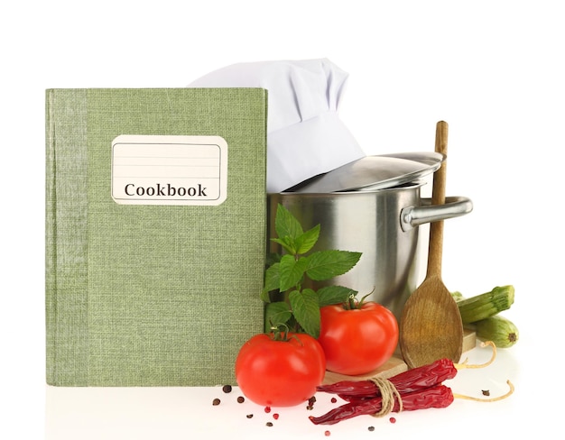 Vegetales de libros de cocina y cazuela aislados en blanco