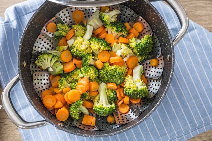 Vegetales mixtos al vapor en una olla negra. Concepto de vegetales saludables.