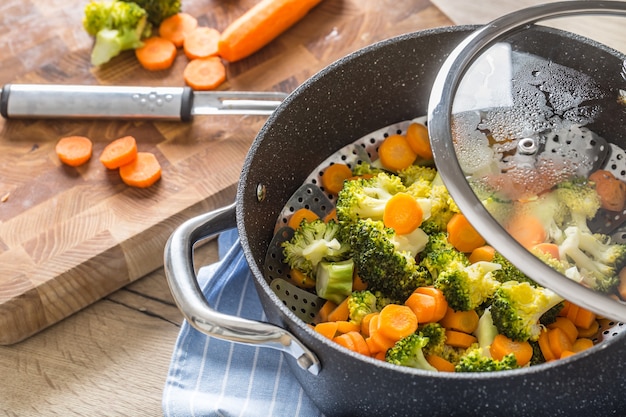 Vegetales mixtos al vapor en una olla negra. Concepto de vegetales saludables.