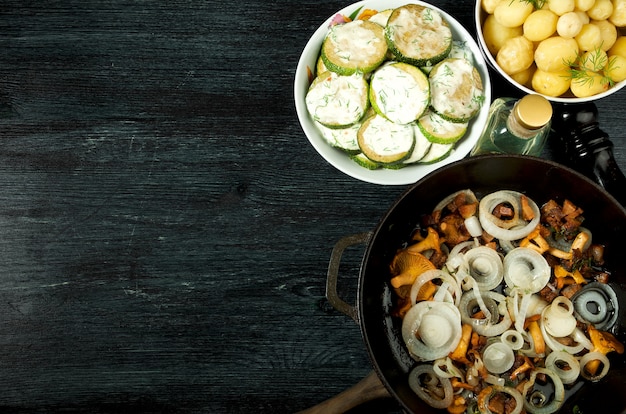 Vegetales . Salsa de calabacín frita en un plato. Patatas hervidas jóvenes con eneldo en un tazón. Rebozuelos fritos con cebolla dorada en una sartén. copyspace