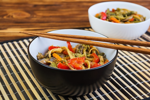 Vegetales salteados con fideos sobre fondo de madera