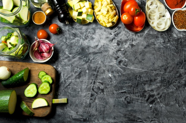 Vegetales . Verduras frescas (pepinos, tomates, cebollas, ajo, eneldo, judías verdes) sobre un fondo gris. Vista superior. copyspace