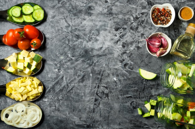 Vegetales . Verduras frescas (pepinos, tomates, cebollas, ajo, eneldo, judías verdes) sobre un fondo gris. Vista superior. copyspace