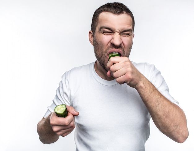 vegetariano mordiendo un gran trozo de pepino verde y bueno