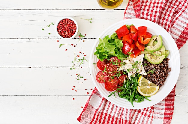 Vegetarische Buddha-Schüssel mit Quinoa, Tofukäse und Frischgemüse. Gesundes Lebensmittelkonzept. Veganer Salat. Ansicht von oben. Flach liegen