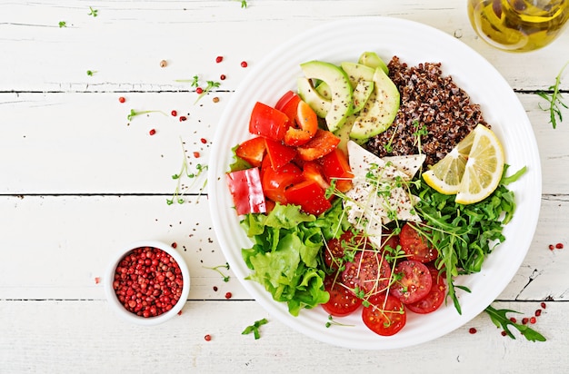 Vegetarische Buddha-Schüssel mit Quinoa, Tofukäse und Frischgemüse. Gesundes Lebensmittelkonzept. Veganer Salat. Ansicht von oben. Flach liegen