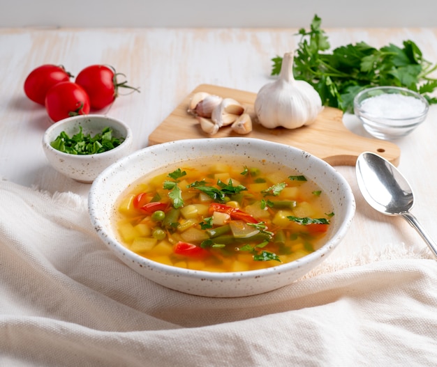 Vegetarische diätetische vegetarische Suppe des gesunden Frühlinges, weißer hölzerner Hintergrund