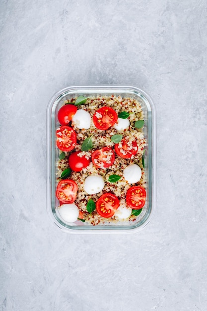 Vegetarische Essenszubereitungs-Lunchbox-Behälter mit Quinoa-Mozzarella-Käse-Tomaten und Basilikum Kopierraum von oben