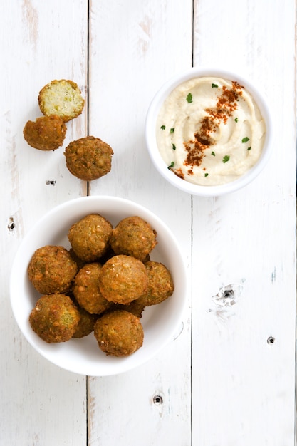 Vegetarische Falafels in Schüssel und Hummus auf Draufsicht des weißen Holzes