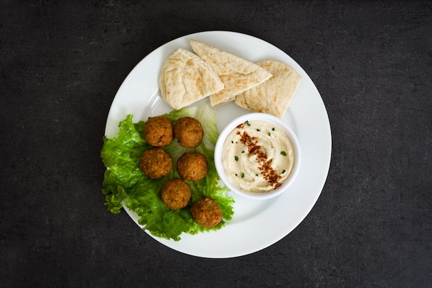 Vegetarische Falafels und Hummus auf schwarzer Schieferplatte