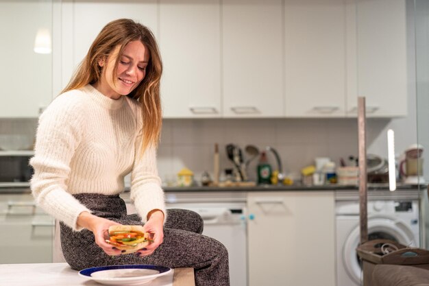 Vegetarische Frau isst ein Gemüsesandwich in der Küche zu Hause gesunde Ernährung