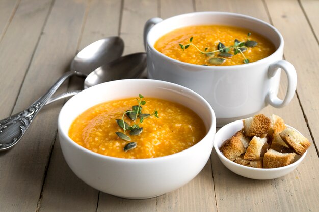 Vegetarische Kürbissuppe auf einem Holztisch.