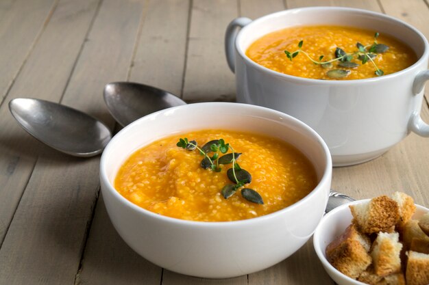 Vegetarische Kürbissuppe auf einem Holztisch.