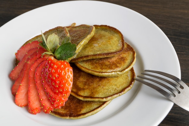 Vegetarische Pfannkuchen mit reifen Erdbeeren. auf einem holztisch.