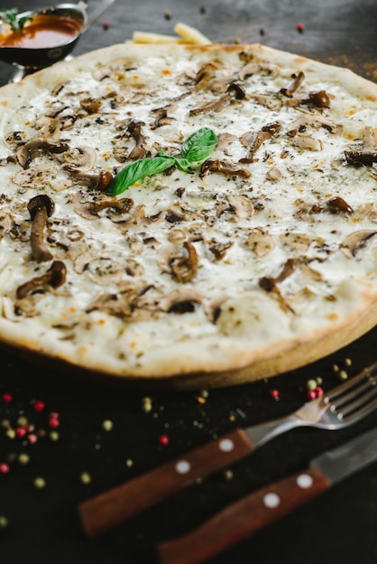 Vegetarische Pilzpizza auf schwarzem Hintergrund