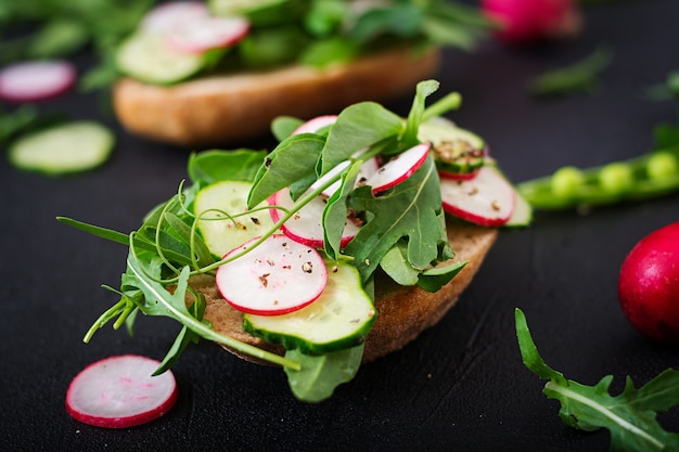 Vegetarische Sandwiches mit Gurke, Rettich, Rucola und grünen Erbsen