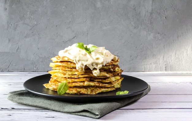 Vegetarische Zucchini-Pfannkuchen mit Basilikumblättern auf einem Teller Das Konzept der gesunden Ernährung Banner