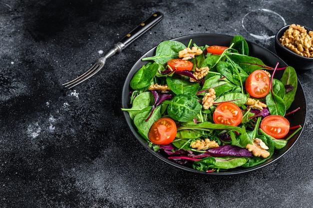 Vegetarischer Salat mit Mischblättern Mangold, Mangold, Spinat, Rucola und Nüssen in einer Salatschüssel