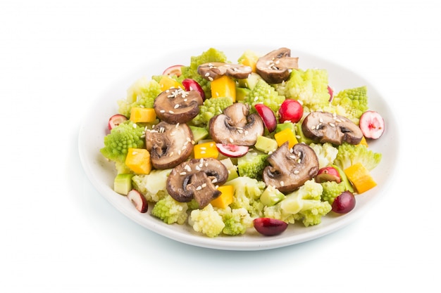 Vegetarischer Salat vom Romanesco Kohl, von den Champignons, von der Moosbeere, von der Avocado und vom Kürbis lokalisiert. Seitenansicht.