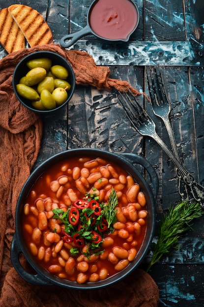 Vegetarisches Menü Geschmorte Bohnen in Tomatensoße mit Petersilie und Chili In einer schwarzen Schüssel Ansicht von oben Freier Platz für Ihren Text