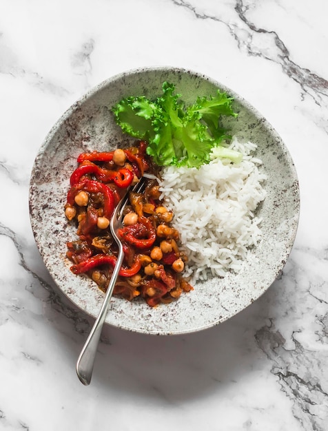 Vegetarisches Mittagessen Reis und Auberginen Paprika Tomaten Kichererbsen Eintopf auf einem hellen Hintergrund Draufsicht