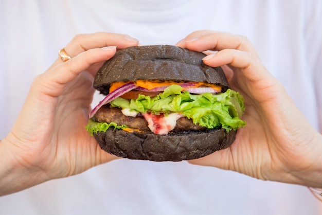 Veggie-Burger und Frauenhand mit Veganer mit einem glutenfreien Klumpen mit Leinsamen und Saft