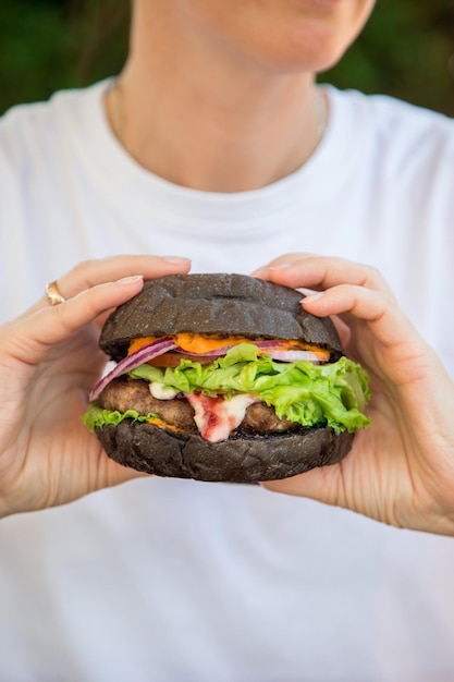 Veggie-Burger und Frauenhand mit Veganer mit einem glutenfreien Klumpen mit Leinsamen und Saft