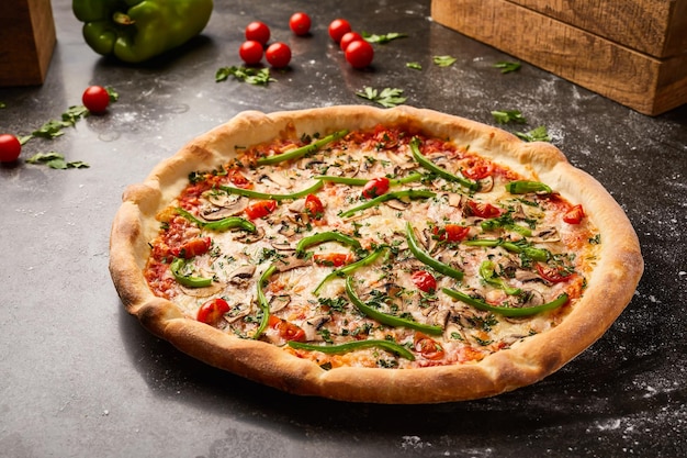 Veggie-Pizza mit Kirsch, Tomaten, Pilzen, Capsicum und Koriander, isoliert auf dunklem Hintergrund mit rohem Essen, oberster Blick auf italienische Fastfood-Appetizer