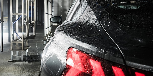 Foto vehículo moderno dentro de un lavado de autos sin contacto