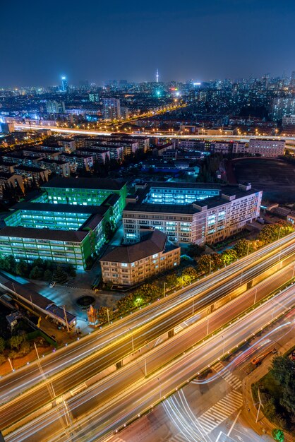 Vehículo pistas en edificios urbanos y carreteras elevadas, vista nocturna, vista aérea, China