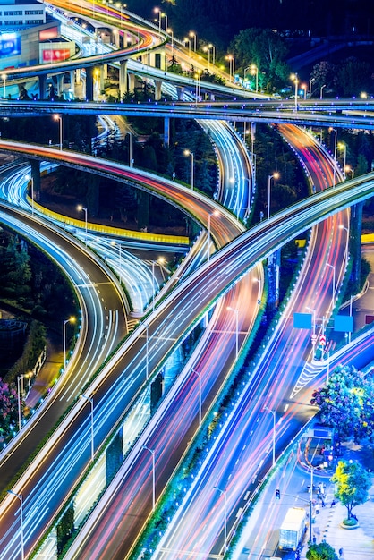 Vehículo pistas en edificios urbanos y carreteras elevadas, vista nocturna, vista aérea, China