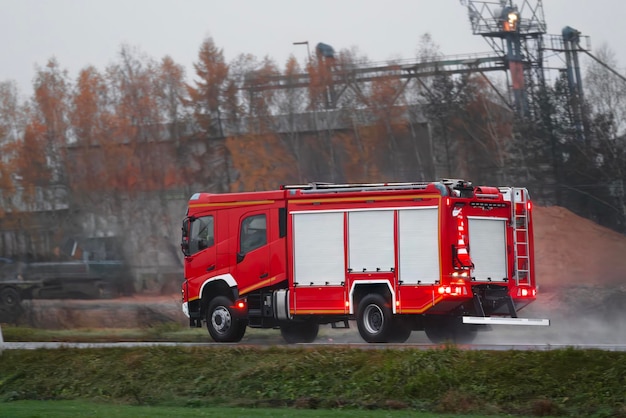 Un vehículo con una sirena conduce a un incendio Es un camión de bomberos con bomberos y equipos de bomberos