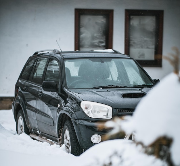 Veículo offroad estacionado durante a queda de neve Conceito de uso de SUV compacto de todas as rodas no inverno