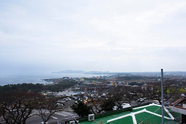 Veja a paisagem da ilha de jeju e a paisagem marítima do oceano com a paisagem urbana da cidade de Seogwipo no ponto de vista para viajantes coreanos que viajam visitam o templo de Sanbangsa em 18 de fevereiro de 2023 em Jeju, Coreia do Sul