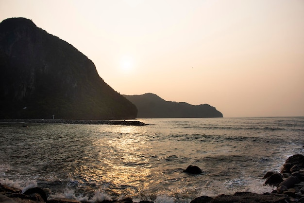 Veja a paisagem marinha e acene no oceano do mar com a montanha da ilha enquanto o nascer do sol da manhã amanhece para o povo tailandês, os viajantes viajam, visitam, relaxam na cidade de Khlong Wan, em Prachuap Khiri Khan, Tailândia