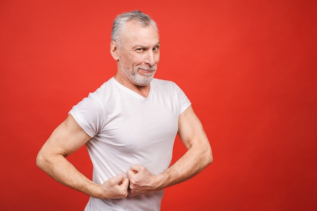 Veja isso! Músculo apresentando homem sênior. Homem envelhecido, flexionando os braços isolados. Alegre animado moderno legal pensionista vovô praticando musculação.