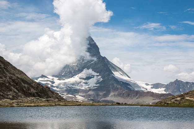 Veja o close up Lago Riffelsee e montanha Matterhorn, cenas no Parque Nacional de Zermatt, Suíça, Europa. Paisagem de verão, clima ensolarado, céu azul dramático e dia ensolarado