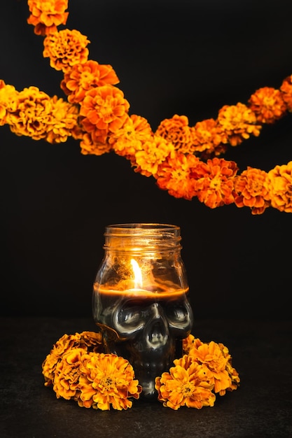 Vela acesa Crânio com coroa de flores de calêndula e guirlandas Dia de los muertos dia ou dia dos mortos