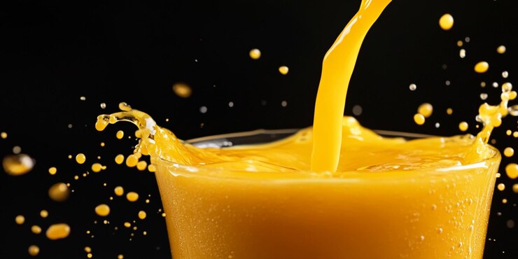 una vela amarilla con jugo de naranja vertiendo en ella