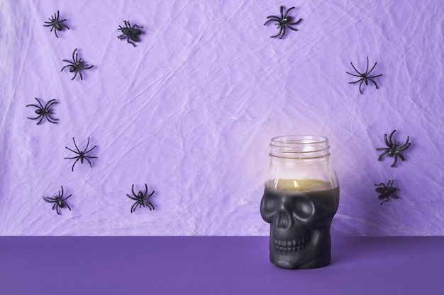 Vela de calavera y telaraña con arañas sobre fondo morado Decoraciones de fiesta de Halloween